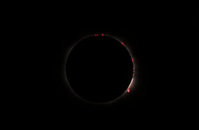 Verfinsterte Sonne mit Protuberanzen